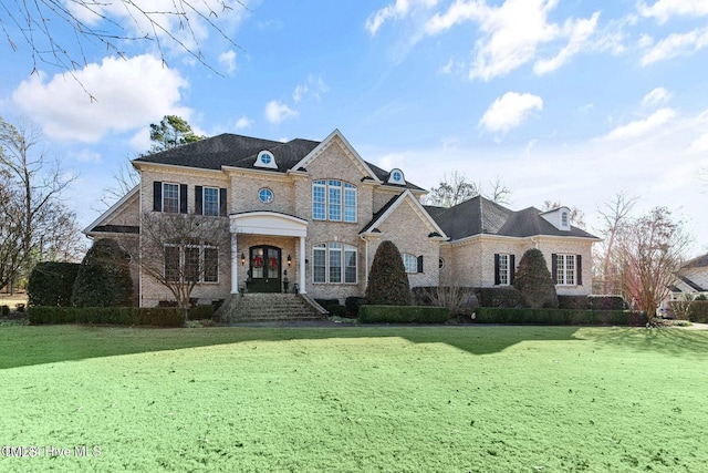 french provincial home with french doors and a front lawn