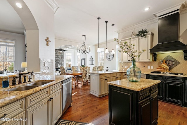 kitchen featuring a center island, sink, tasteful backsplash, premium range hood, and appliances with stainless steel finishes