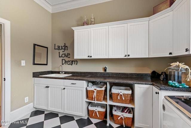 laundry room featuring crown molding, cabinets, and sink