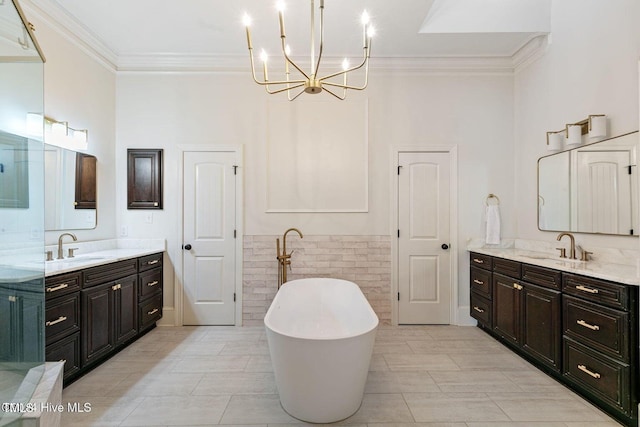 bathroom with a washtub, vanity, and crown molding