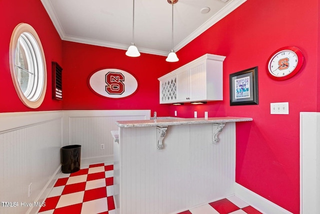 bar featuring white cabinets, pendant lighting, and crown molding