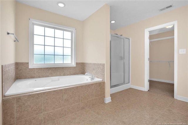 bathroom with tile patterned flooring and separate shower and tub