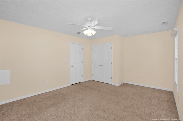 unfurnished bedroom featuring light colored carpet and ceiling fan