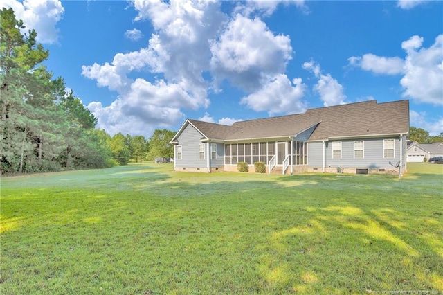 rear view of house with a sunroom and a yard