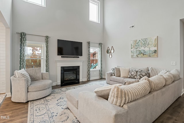 living room with plenty of natural light, hardwood / wood-style floors, and a high ceiling