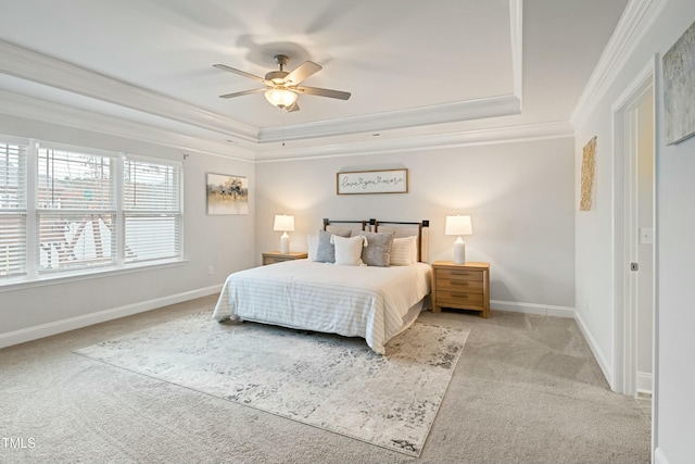 bedroom featuring a tray ceiling, ceiling fan, crown molding, and light colored carpet