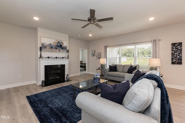 living room with ceiling fan and light hardwood / wood-style flooring