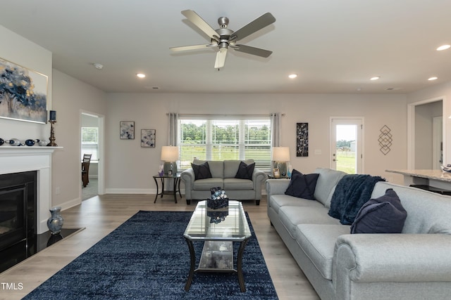 living room featuring wood-type flooring and ceiling fan