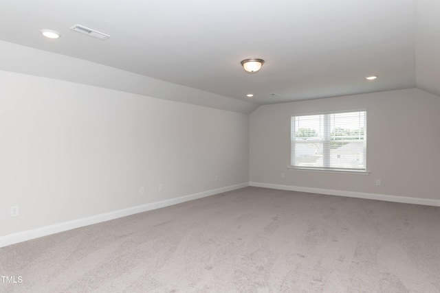 unfurnished room featuring carpet floors and vaulted ceiling