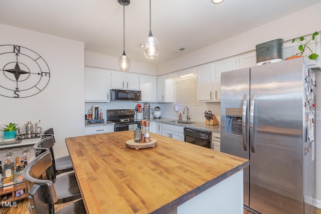 kitchen featuring sink, a kitchen island, tasteful backsplash, white cabinets, and black appliances