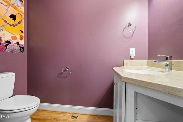 bathroom featuring wood-type flooring, vanity, and toilet