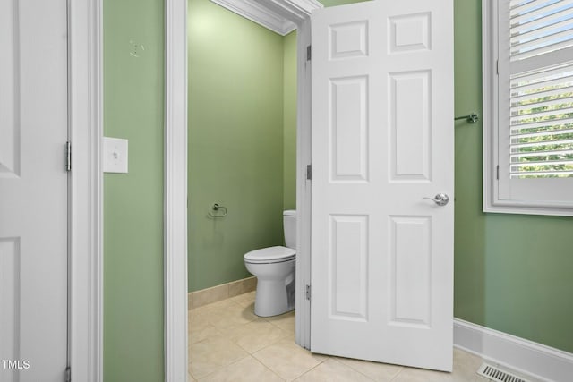 bathroom with tile patterned flooring, toilet, and ornamental molding