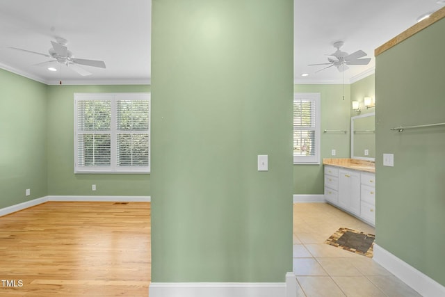 bathroom featuring crown molding, vanity, a healthy amount of sunlight, and ceiling fan