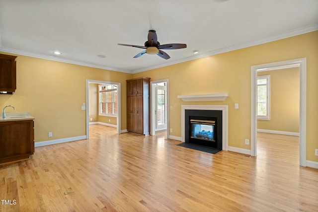 unfurnished living room featuring crown molding, light hardwood / wood-style flooring, and ceiling fan