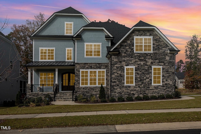 craftsman-style house with a porch and a yard