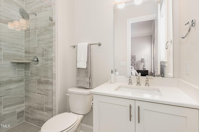 bathroom featuring tiled shower, vanity, and toilet