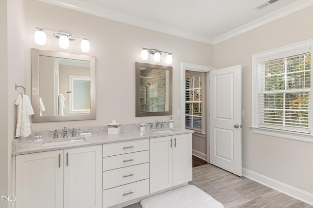 bathroom featuring crown molding, vanity, wood-type flooring, and walk in shower