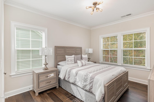 bedroom featuring dark hardwood / wood-style flooring, ornamental molding, and an inviting chandelier