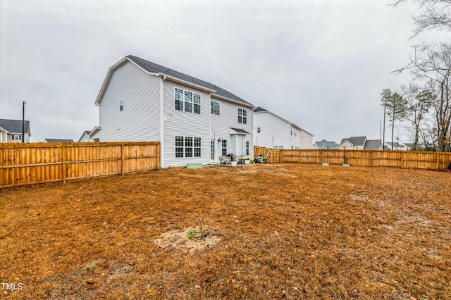 rear view of house with a fenced backyard