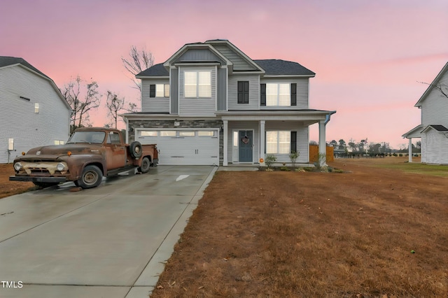 view of front of house with a yard, a porch, and a garage