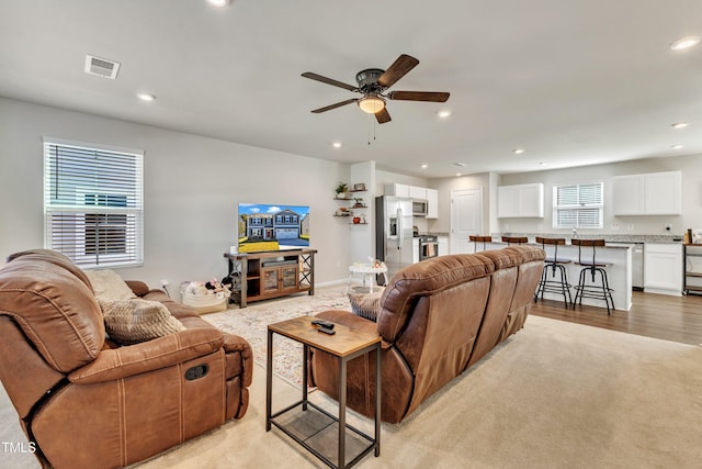 living room featuring ceiling fan and light carpet