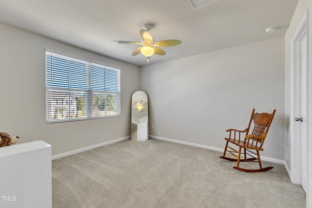 living area with light carpet and ceiling fan