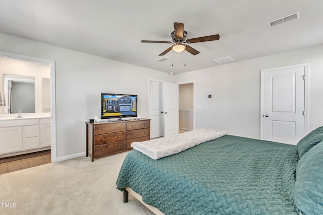 carpeted bedroom with ensuite bath, ceiling fan, and sink