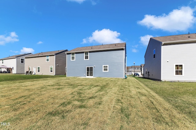 rear view of property featuring a lawn