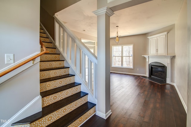 stairway with hardwood / wood-style floors and ornate columns