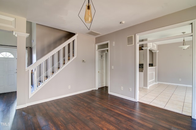 interior space featuring decorative columns and hardwood / wood-style floors