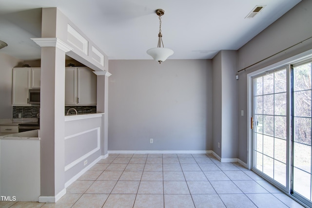 unfurnished dining area featuring light tile patterned floors