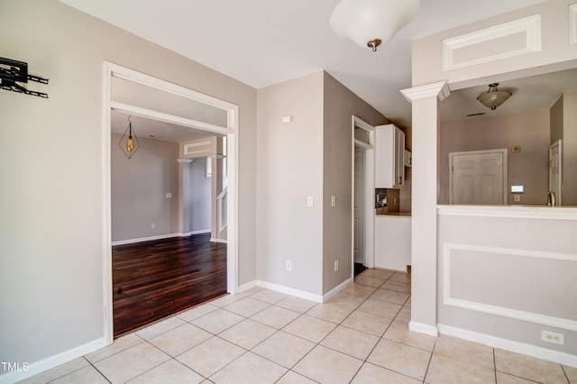 tiled empty room featuring decorative columns