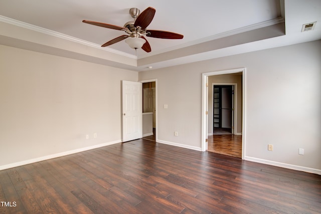 empty room featuring a raised ceiling, crown molding, dark hardwood / wood-style floors, and ceiling fan