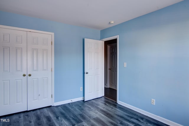 unfurnished bedroom featuring dark hardwood / wood-style flooring and a closet