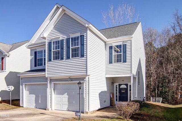 traditional-style home featuring concrete driveway, a garage, and a shingled roof