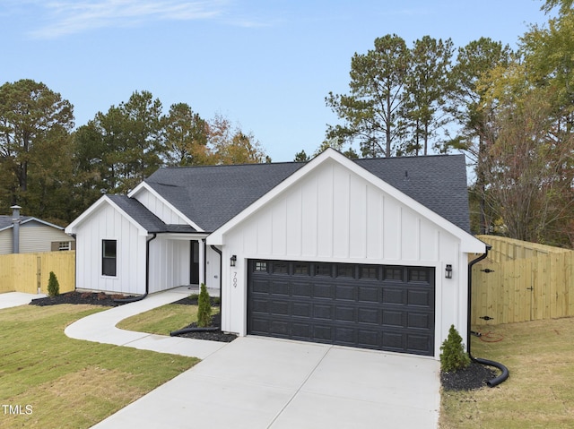 modern inspired farmhouse with a front lawn and a garage