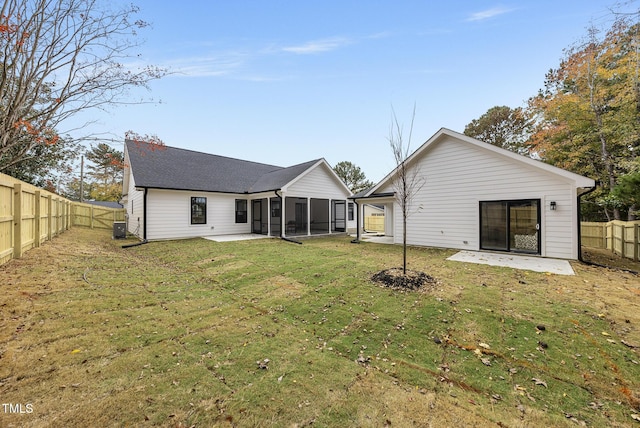 back of property with a sunroom, a yard, a patio, and central AC unit