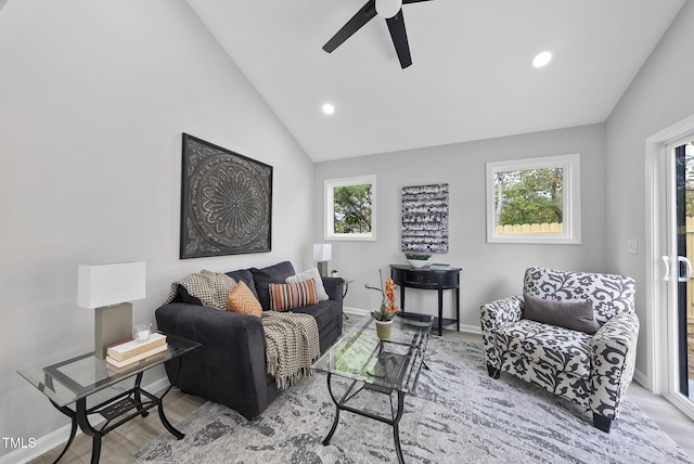 living room featuring light hardwood / wood-style flooring, vaulted ceiling, and ceiling fan