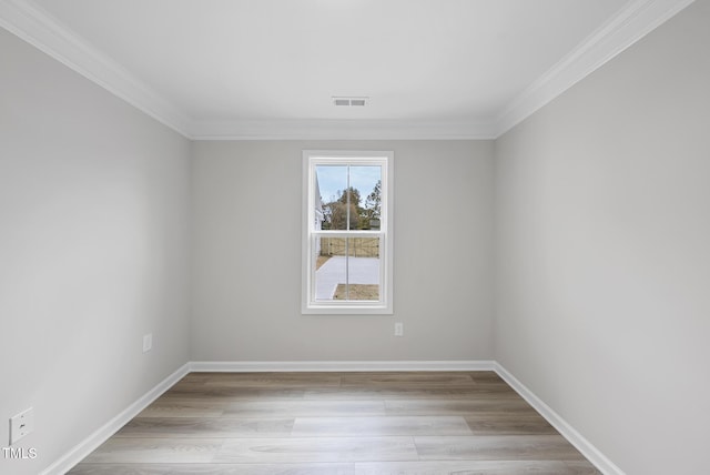 spare room featuring light hardwood / wood-style floors and ornamental molding