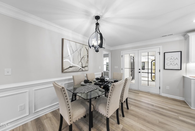 dining space featuring a notable chandelier, plenty of natural light, ornamental molding, and french doors