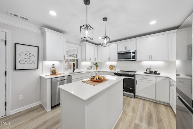 kitchen with white cabinetry, a center island, sink, stainless steel appliances, and decorative backsplash