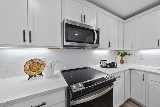 kitchen featuring backsplash, white cabinets, and appliances with stainless steel finishes