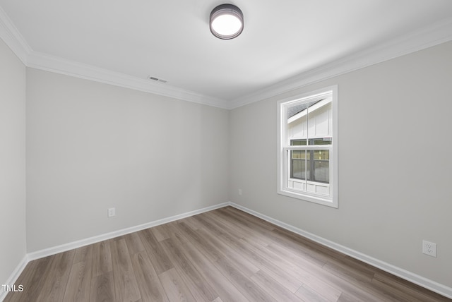 spare room featuring crown molding and light hardwood / wood-style flooring