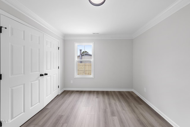 spare room featuring light hardwood / wood-style flooring and ornamental molding