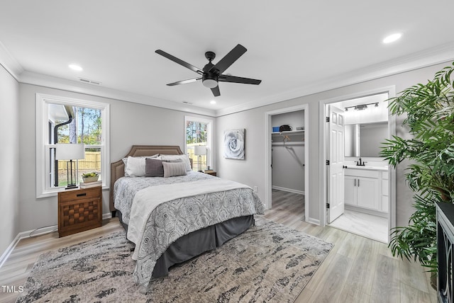 bedroom with ensuite bathroom, light hardwood / wood-style flooring, ceiling fan, a spacious closet, and a closet