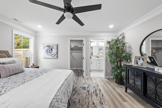 bedroom featuring connected bathroom, ceiling fan, a spacious closet, light hardwood / wood-style flooring, and crown molding