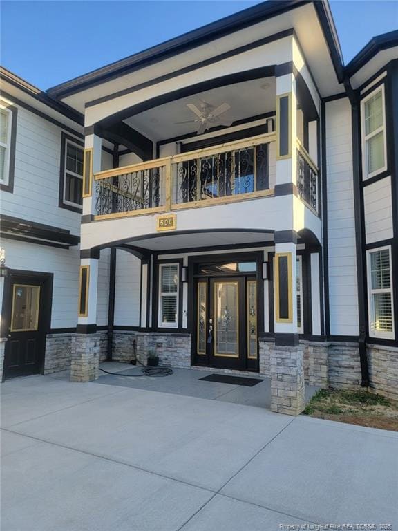 doorway to property featuring a balcony and ceiling fan