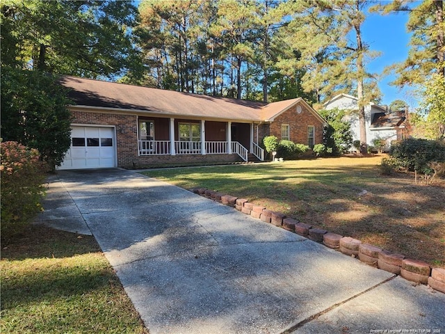 single story home with a garage, concrete driveway, a porch, a front lawn, and brick siding