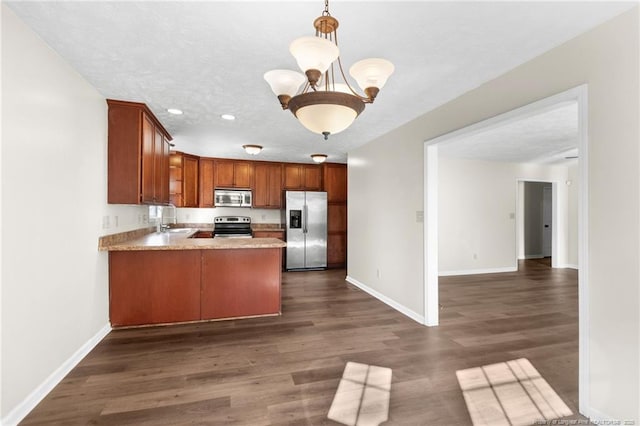 kitchen with sink, decorative light fixtures, a notable chandelier, kitchen peninsula, and stainless steel appliances