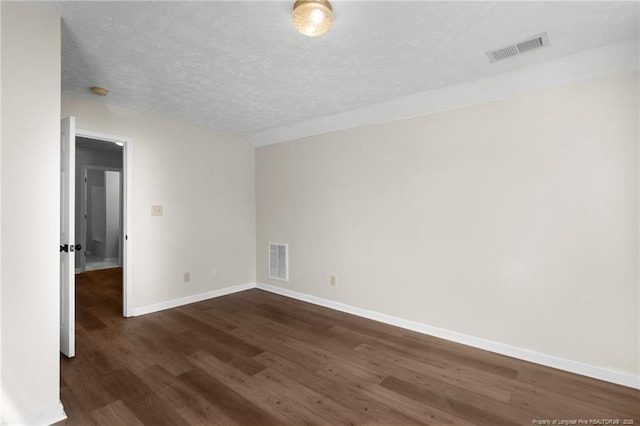 unfurnished room with a textured ceiling and dark hardwood / wood-style flooring